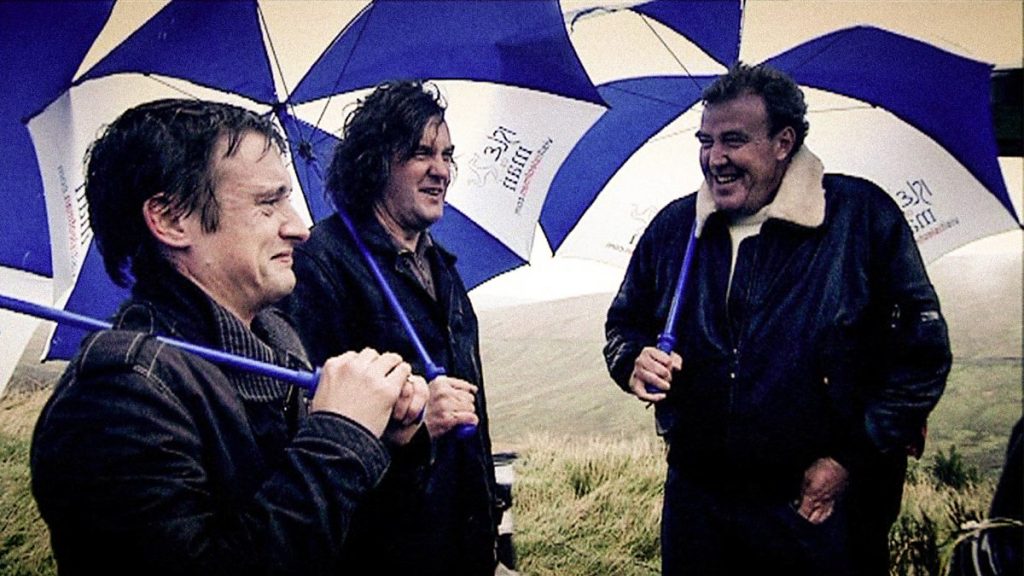 A photo of Jeremy Clarkson, Richard Hammond, and James May together on set.